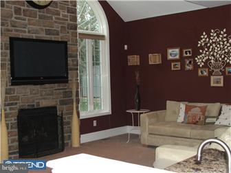 142 Wyndmoor Road Springfield, PA 19064 - Photo 11 of 12 a living room with furniture a fireplace and a flat screen tv