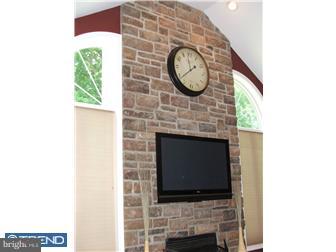142 Wyndmoor Road Springfield, PA 19064 - Photo 10 of 12 a stone wall with a fireplace and a flat screen tv