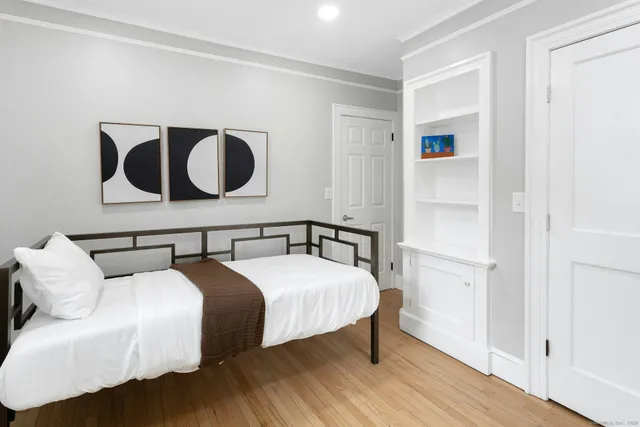 a bedroom with a bed and wooden floor