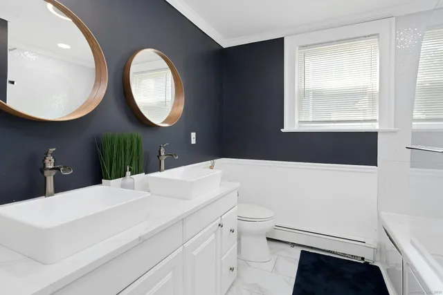 a bathroom with a sink a toilet and a mirror