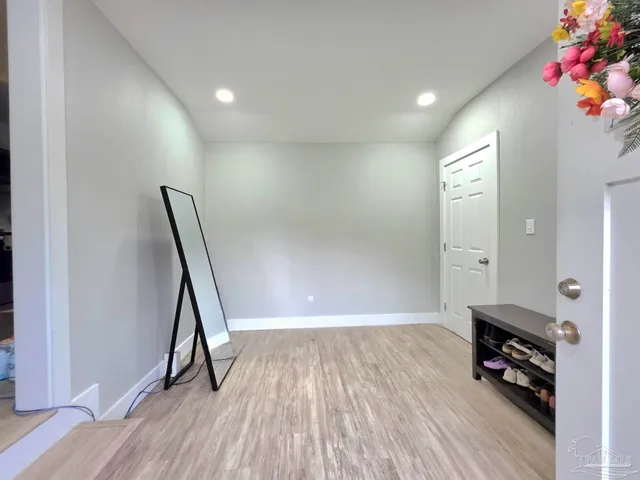 a view of a livingroom with wooden floor and a hallway
