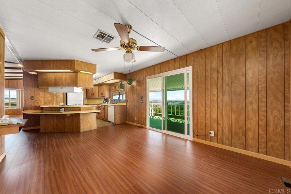 a kitchen with stainless steel appliances kitchen island wooden floors and view living room