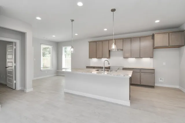 a large kitchen with stainless steel appliances kitchen island granite countertop a sink and cabinets