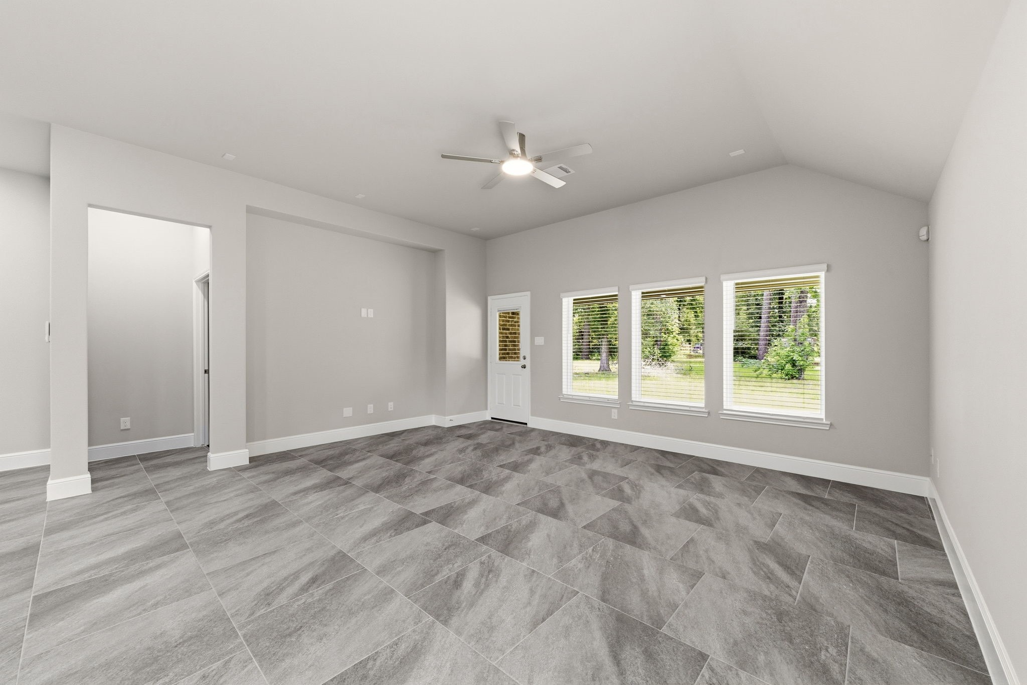 23620 Youpon Lane Spring, TX 77389 - Photo 17 of 37 Light filled living room with vaulted ceilings, elegant tile flooring, and tranquil backyard views.
