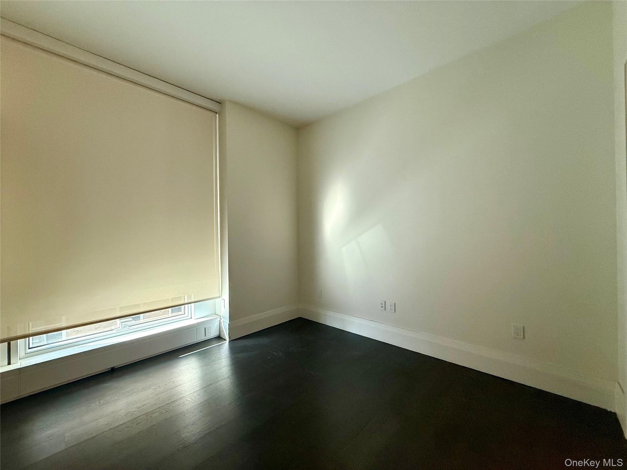 172 Madison Avenue, Unit 17C Manhattan, NY 10016 - Photo 20 of 27 an empty room with a wooden floor and a window