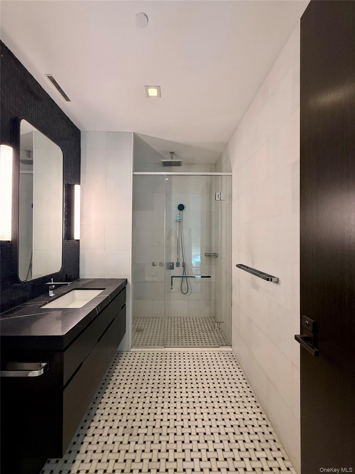 172 Madison Avenue, Unit 17C Manhattan, NY 10016 - Photo 22 of 27 a bathroom with a granite countertop sink a mirror and shower
