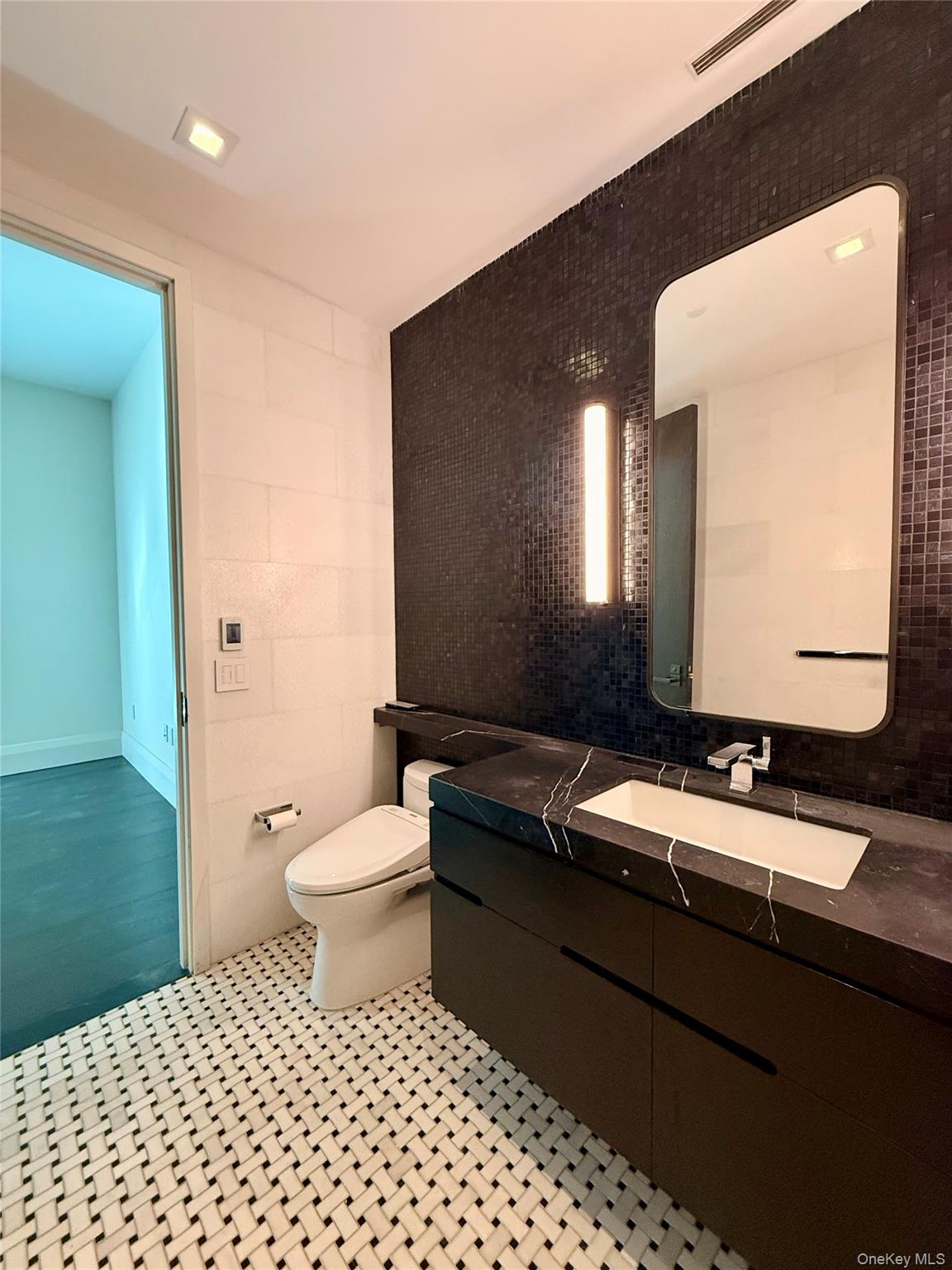 172 Madison Avenue, Unit 17C Manhattan, NY 10016 - Photo 23 of 27 a bathroom with a sink a toilet and mirror