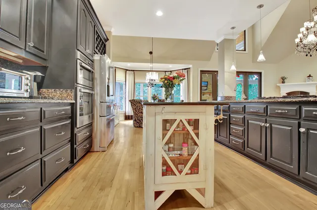 a kitchen with white cabinets a sink dishwasher and a stove with wooden floor