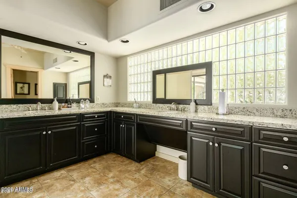 a spacious bathroom with a granite countertop sink and a large mirror