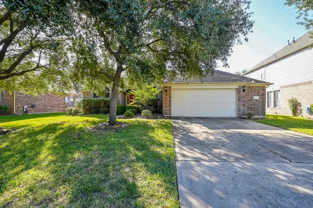 a view of a house with backyard and a tree