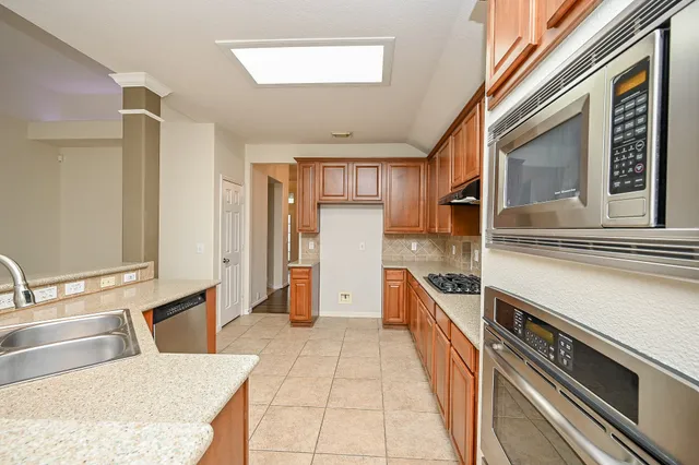 a kitchen with stainless steel appliances granite countertop a sink and dishwasher refrigerator stove