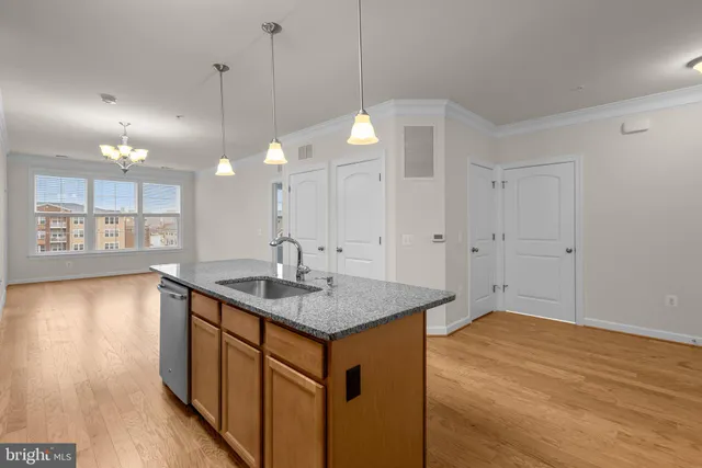 a kitchen with a sink chandelier and wooden floor