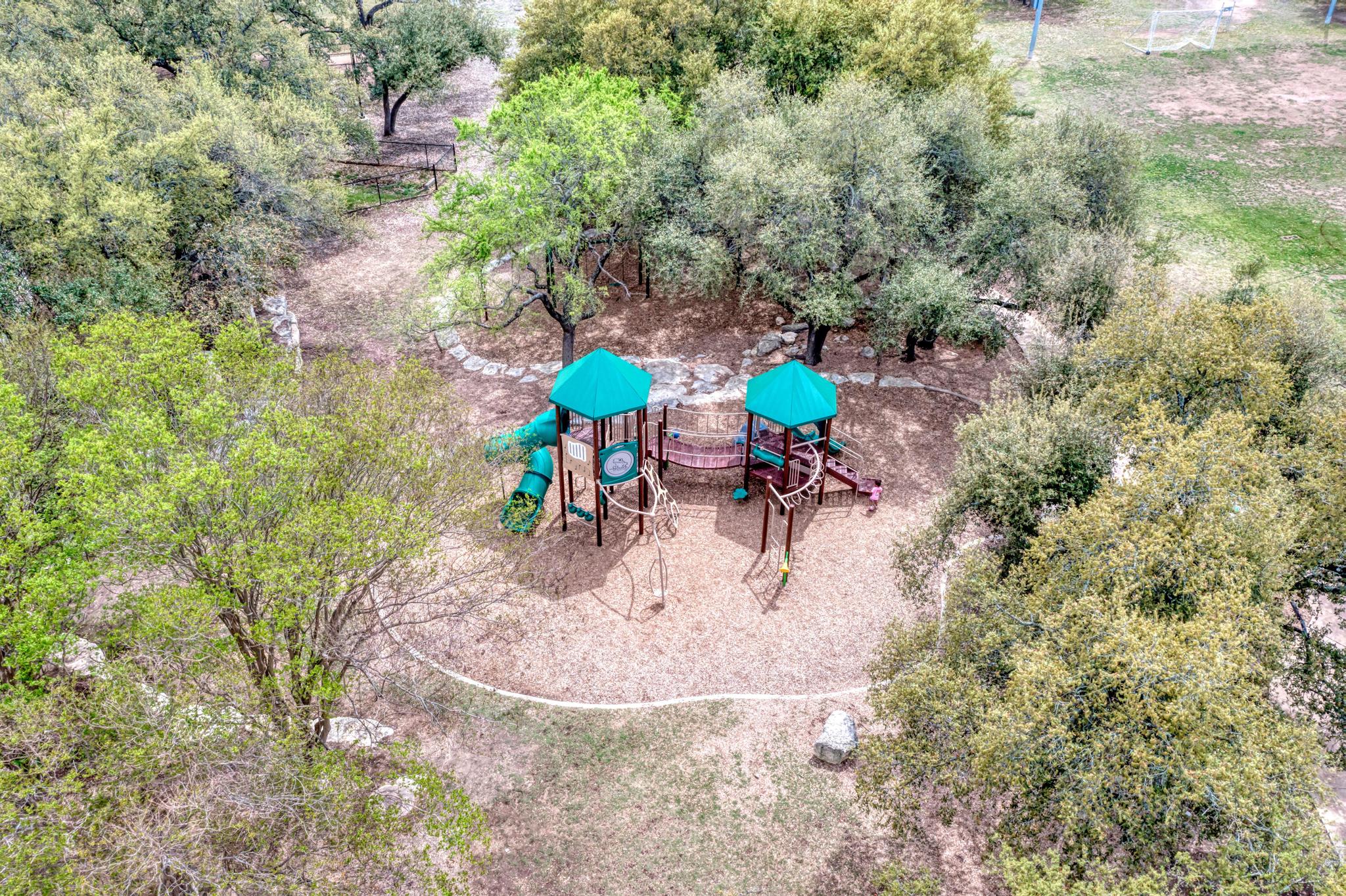 2601 North Quinlan Park Road, Unit 506 Austin, TX 78732 - Photo 37 of 39 A vibrant playground surrounded by lush trees offers endless outdoor fun for all ages.