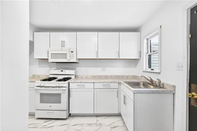 a kitchen with white cabinets and white appliances