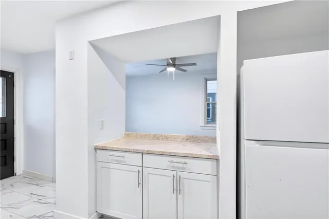 a kitchen with granite countertop a sink stove and refrigerator