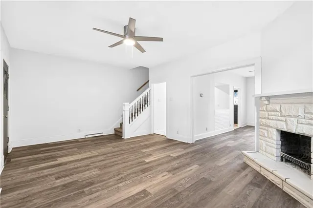 a view of empty room with wooden floor and fireplace