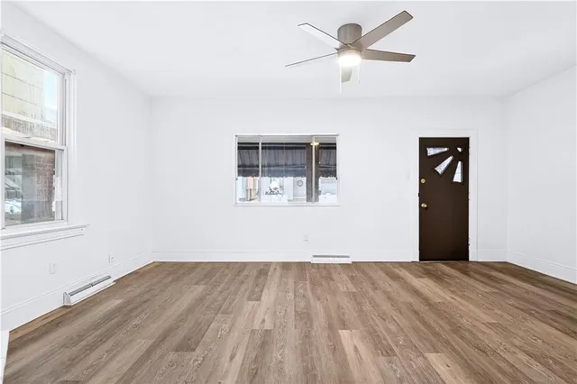 a view of a big room with wooden floor and a chandelier fan