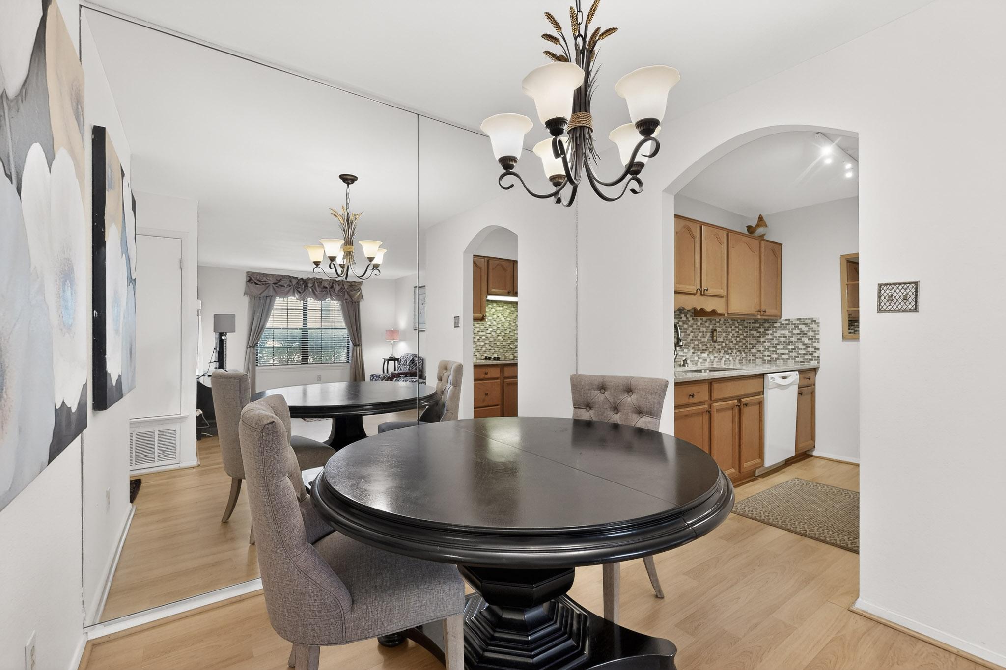 8210 Bent Tree Road, Unit 104 Austin, TX 78759 - Photo 8 of 38 Dining space featuring suspended lighting, arched walkways, and light wood-style floors