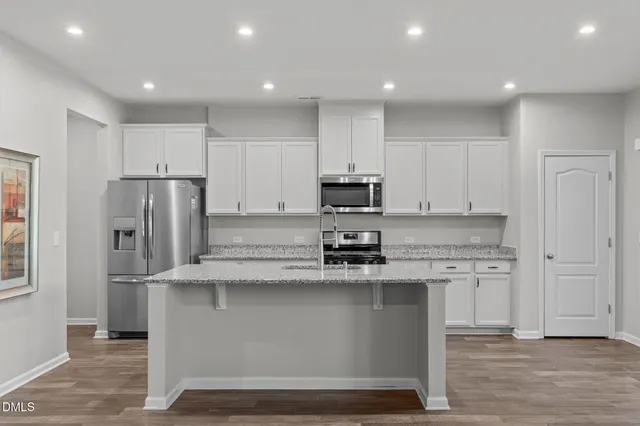 a view of a livingroom with a fireplace a ceiling fan and windows