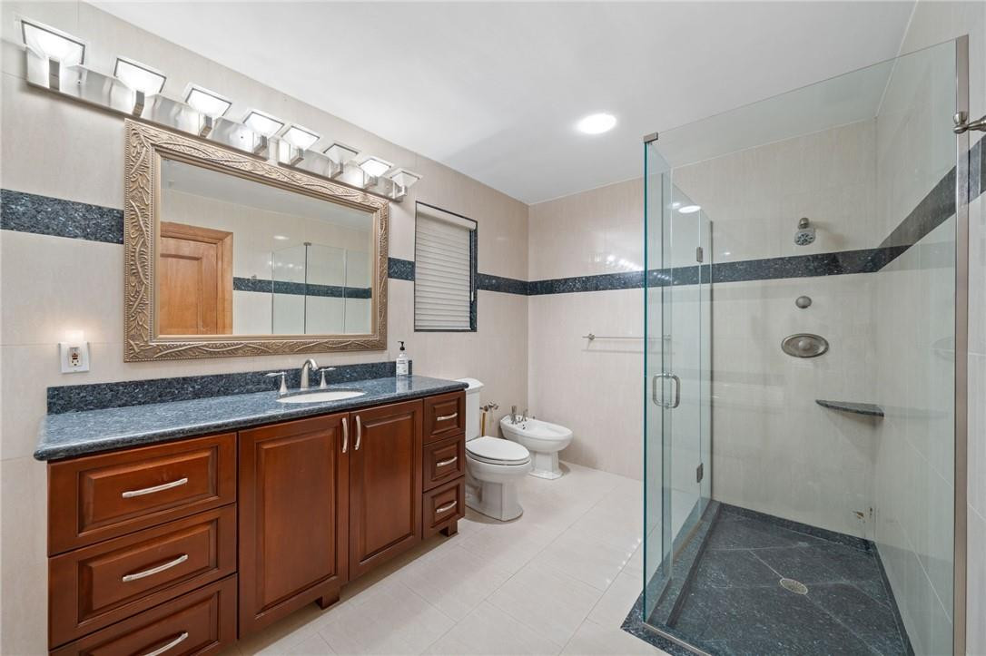 3800 North Park Road Hollywood, FL 33021 - Photo 22 of 27 a bathroom with a granite countertop sink a toilet a mirror and shower