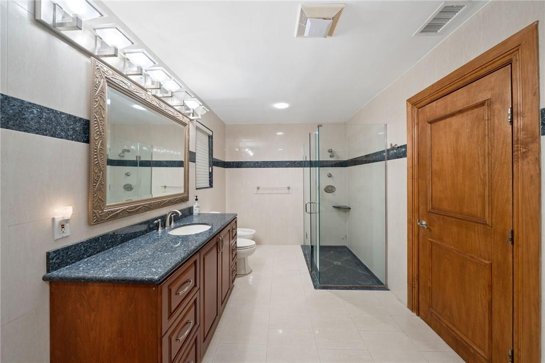3800 North Park Road Hollywood, FL 33021 - Photo 23 of 27 a bathroom with a granite countertop sink a toilet a mirror and shower