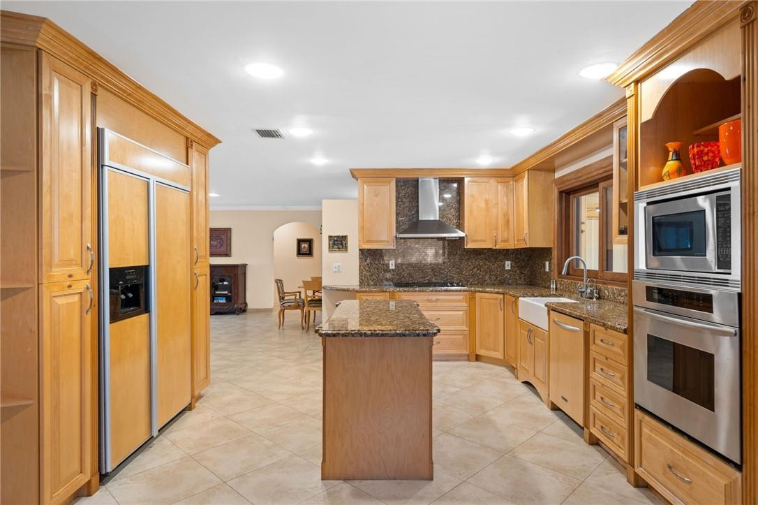 3800 North Park Road Hollywood, FL 33021 - Photo 10 of 27 a kitchen with stainless steel appliances granite countertop a stove top oven a sink a refrigerator and white cabinets with wooden floor