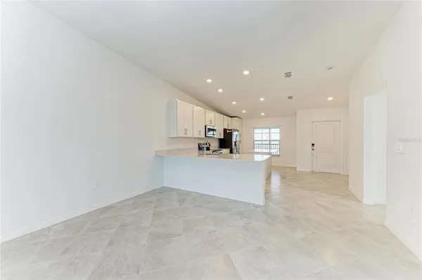 a kitchen with stainless steel appliances a sink a stove a microwave a center island and cabinets