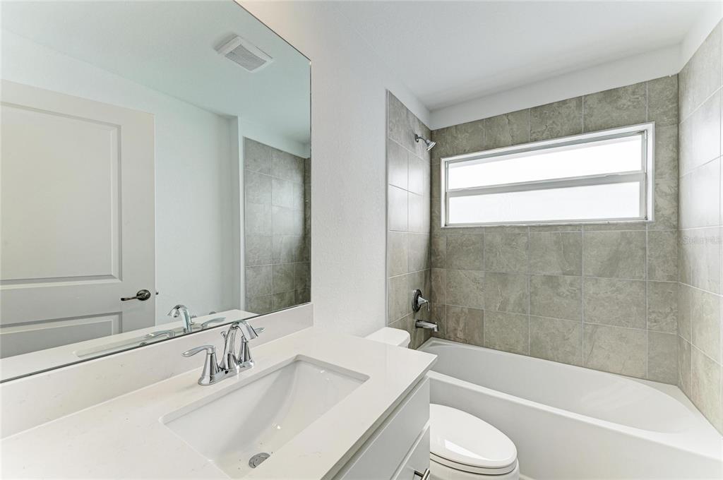 19015 Scallop Loop, Unit 7121 Lakewood Ranch, FL 34211 - Photo 35 of 48 a bathroom with a bathtub shower sink vanity mirror and toilet