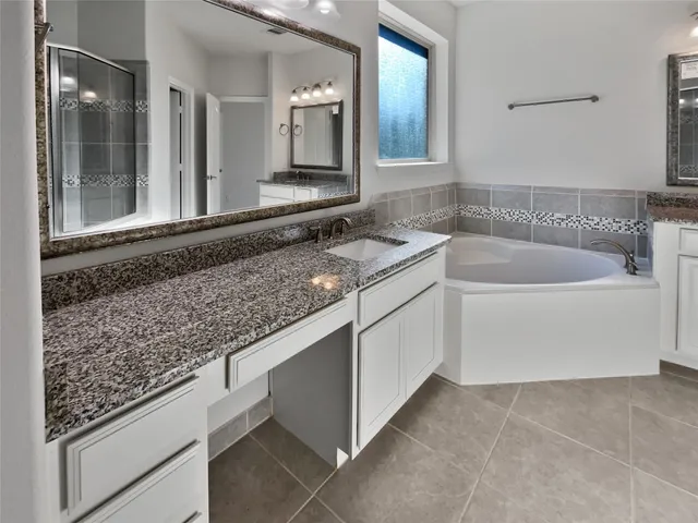 a bathroom with a granite countertop sink and mirror