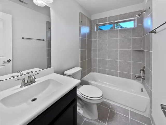 a bathroom with a bathtub shower sink mirror and toilet