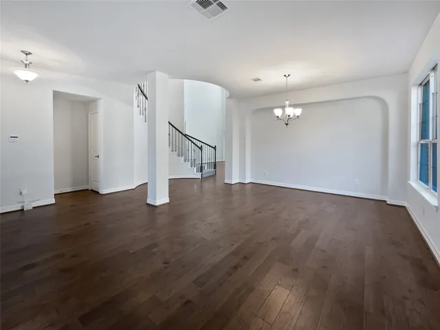 an empty room with wooden floor and white walls