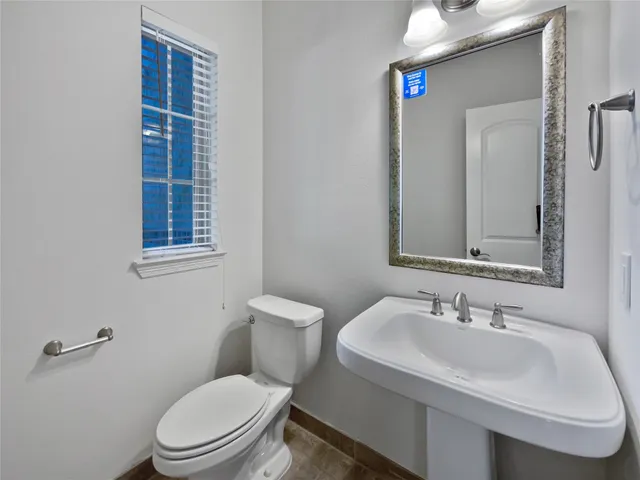 a bathroom with a sink toilet and mirror