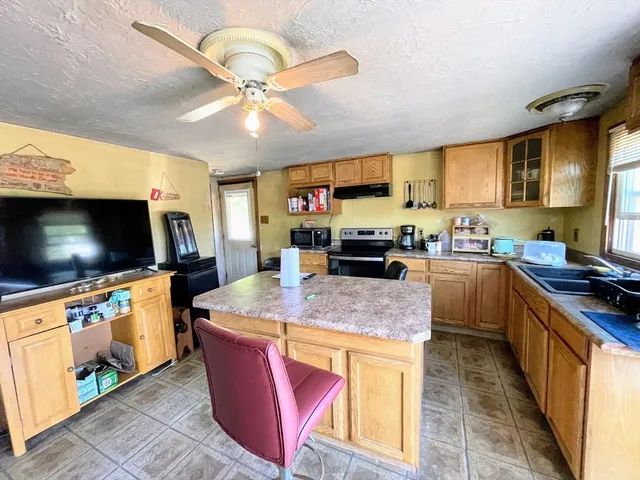 a kitchen with kitchen island a sink appliances and cabinets