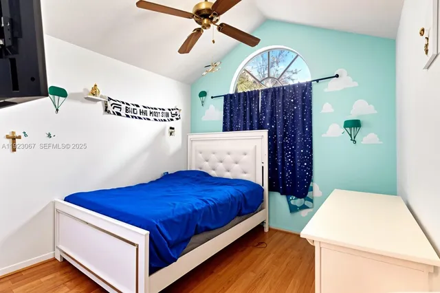 a bedroom with a bed a dresser and paintings on the wall