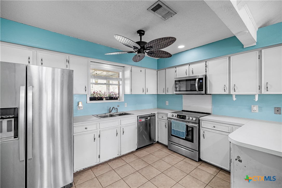 204 Brooks Road Victoria, TX 77904 - Photo 4 of 22 a kitchen with white cabinets stainless steel appliances and a window