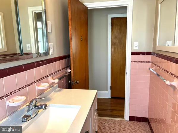 a bathroom with a tub a sink and a large mirror