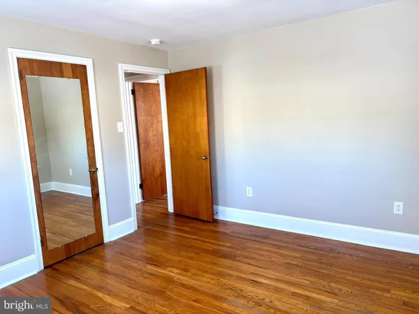 an empty room with wooden floor and closet