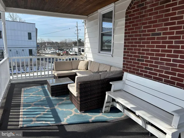 a view of a patio with couches chairs and wooden floor