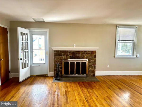 wooden floor fireplace and windows in an empty room