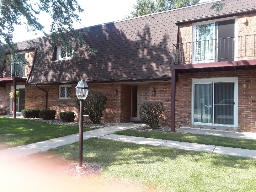 1019 Shagbark Road, Unit 1E New Lenox, IL 60451 - Photo 2 of 15 a front view of a house with garden