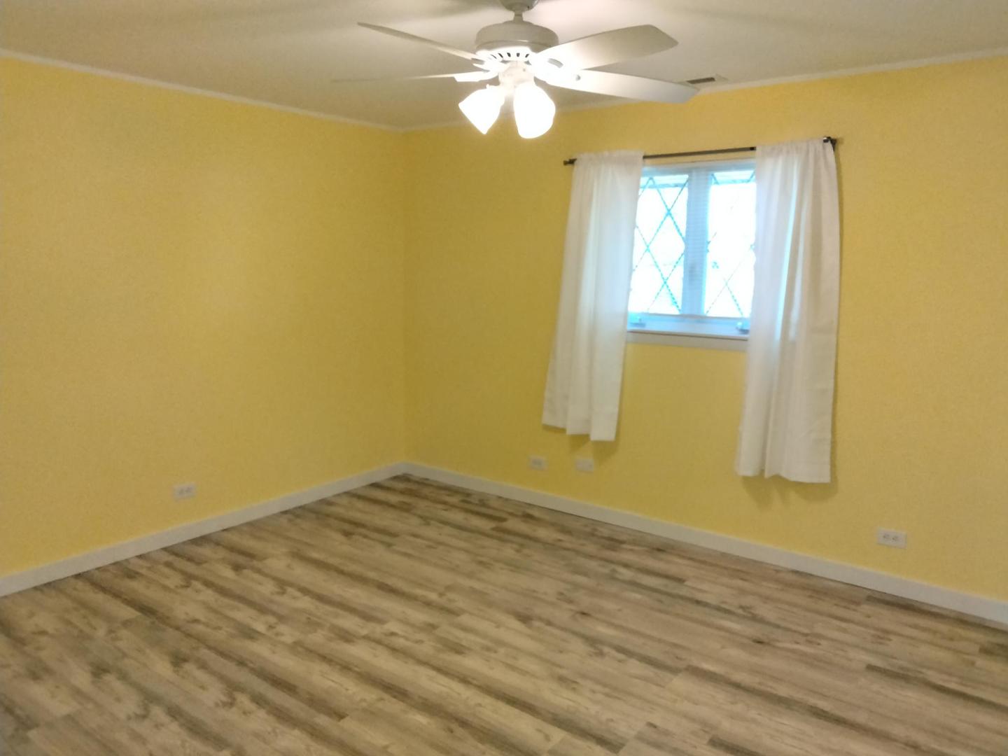 1019 Shagbark Road, Unit 1E New Lenox, IL 60451 - Photo 12 of 15 a view of a bedroom with wooden floor and a ceiling fan