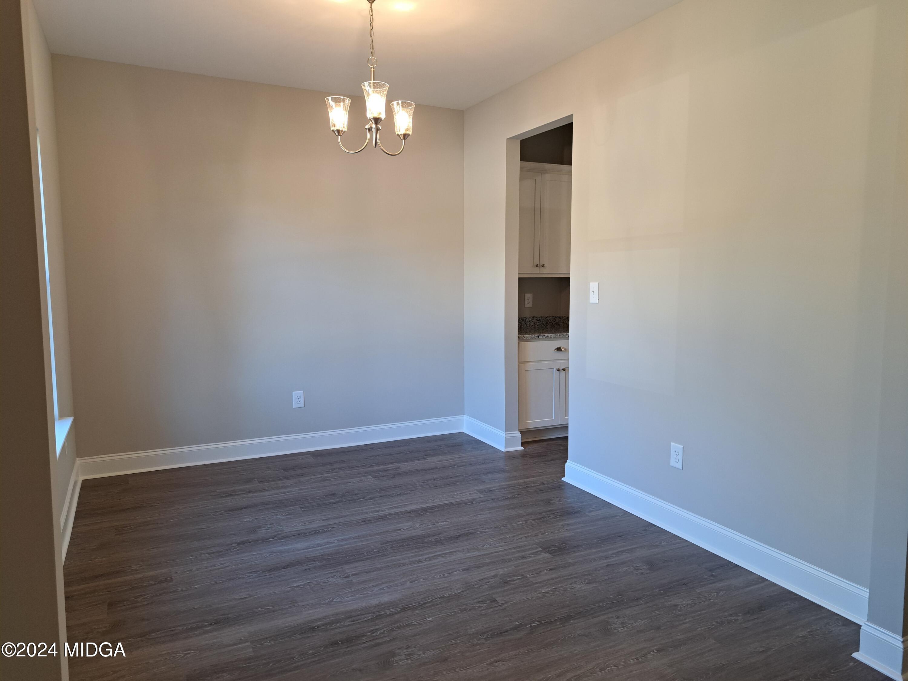 368 Walnut Grove Road Gray, GA 31032 - Photo 3 of 32 an empty room with wooden floor and chandelier