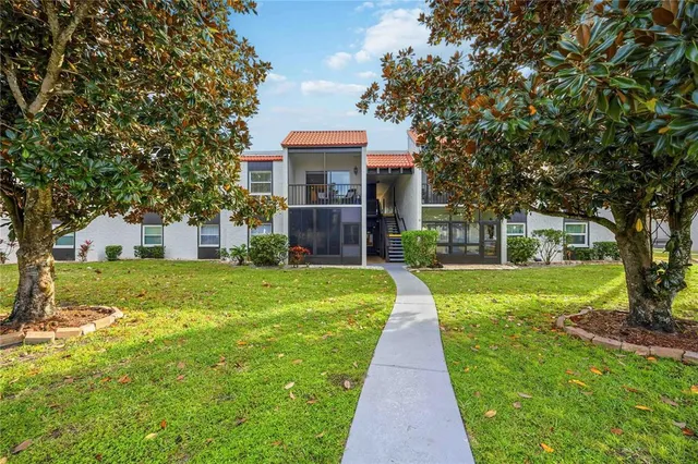 a front view of a house with a yard and trees
