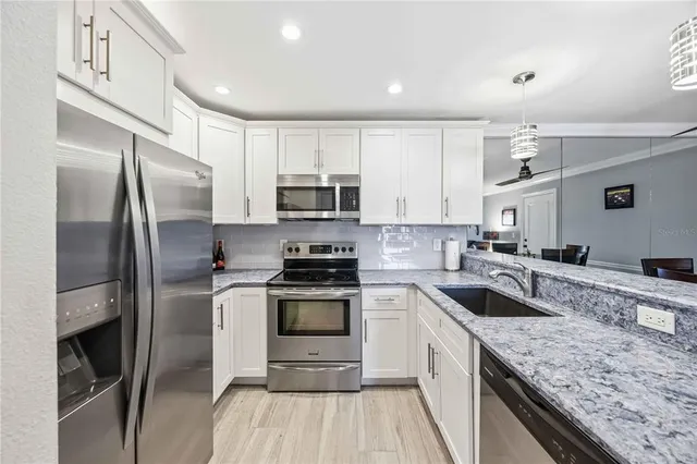 a kitchen with stainless steel appliances granite countertop a stove a sink and a refrigerator