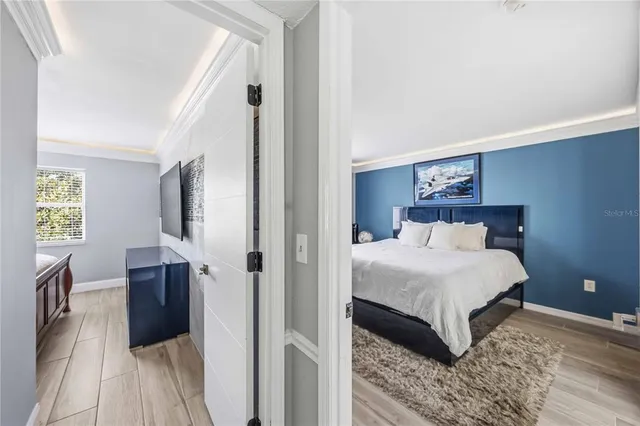 a bedroom with a large bed and a chandelier