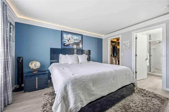 a spacious bedroom with a bed and a flat screen tv