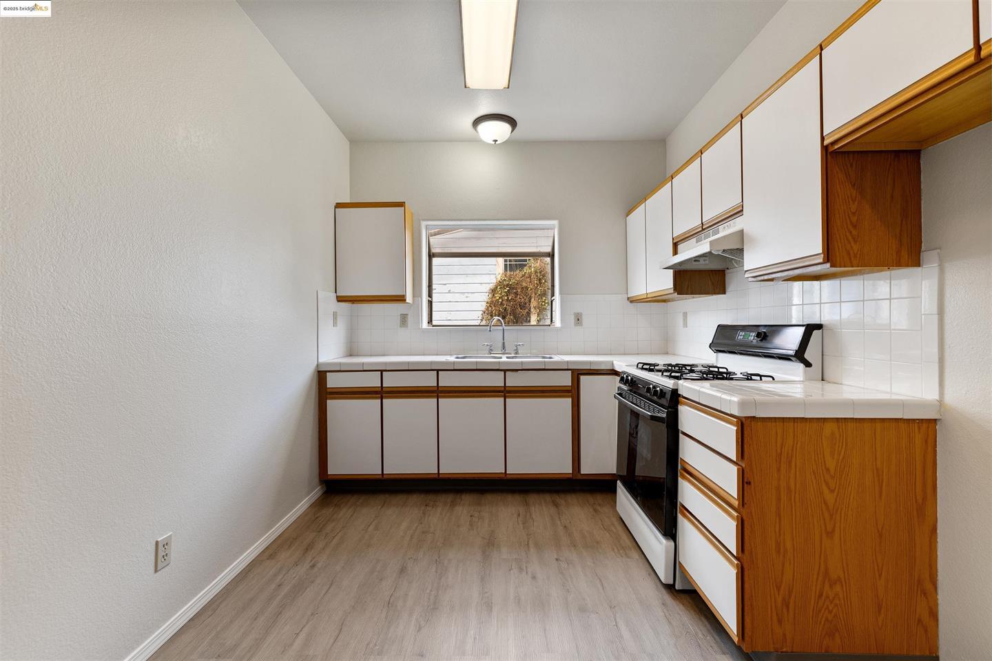 1619 Fairview Street, Unit 2 Berkeley, CA 94703 - Photo 6 of 6 a kitchen with stainless steel appliances granite countertop a stove and a sink