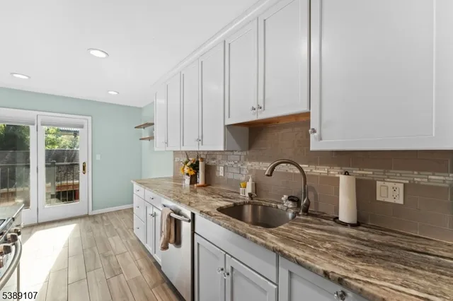 a kitchen with granite countertop a sink a stove and cabinets
