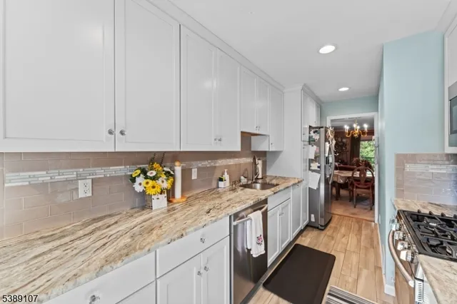a kitchen with stainless steel appliances granite countertop a sink stove and cabinets