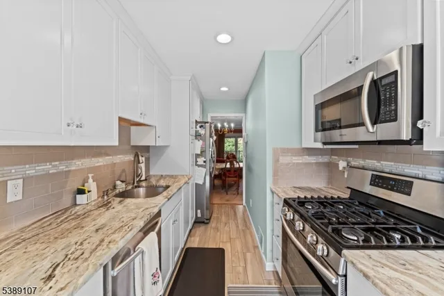 a kitchen with stainless steel appliances granite countertop a stove and a microwave